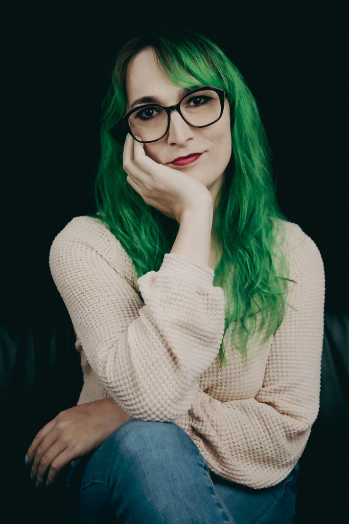 A woman with big glasses and green hair